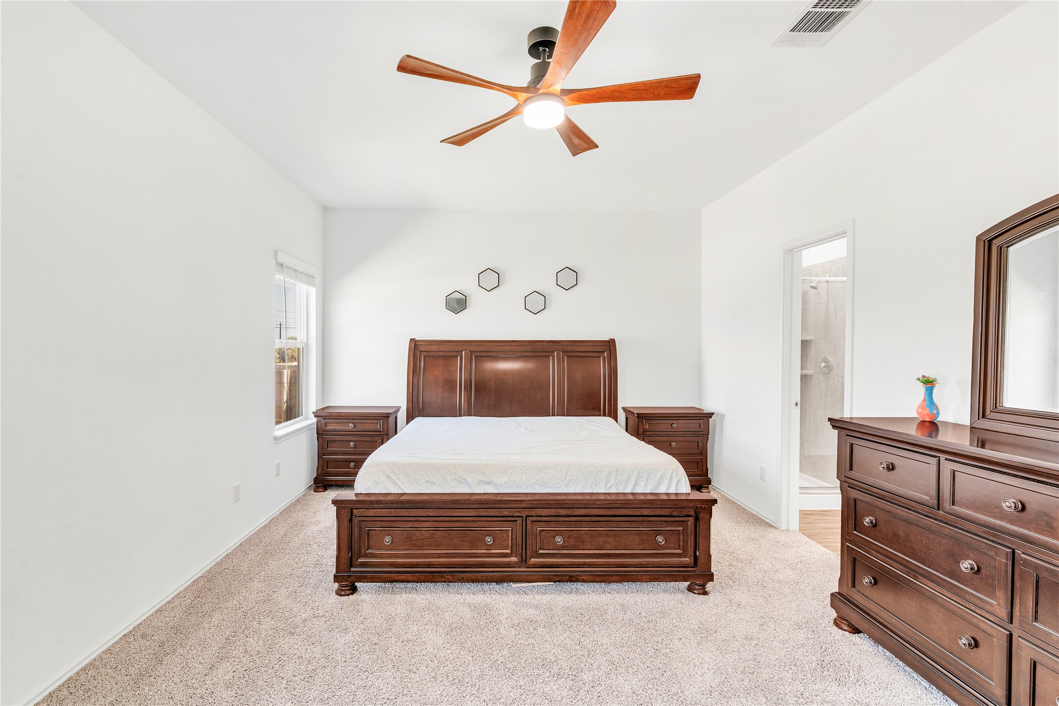 212 Saddle Mountain Road Georgetown, TX 78628 - Photo 19 of 30 A tranquil primary bedroom with plush carpeting and a large window, offering a private retreat.