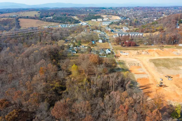 an aerial view of residential houses with outdoor space and trees
