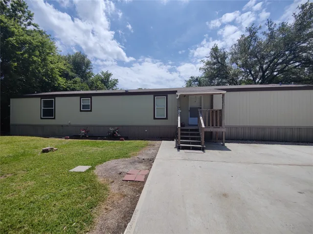 a backyard of a house with barbeque oven and fence
