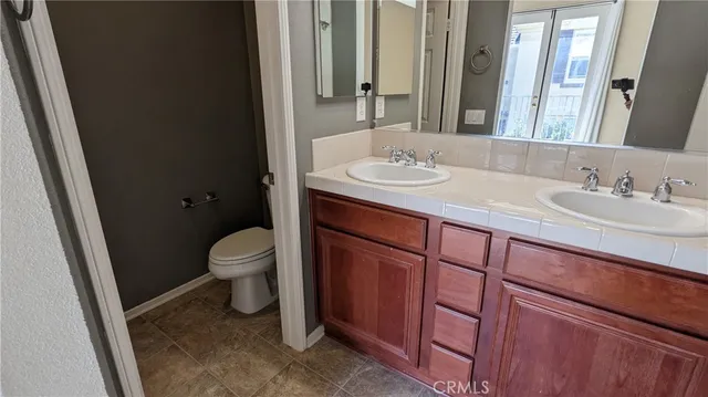 a bathroom with a sink a toilet and mirror