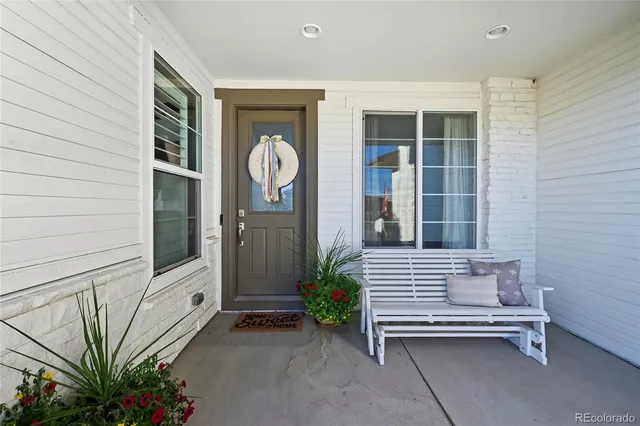 a view of a house with a door and wooden bench