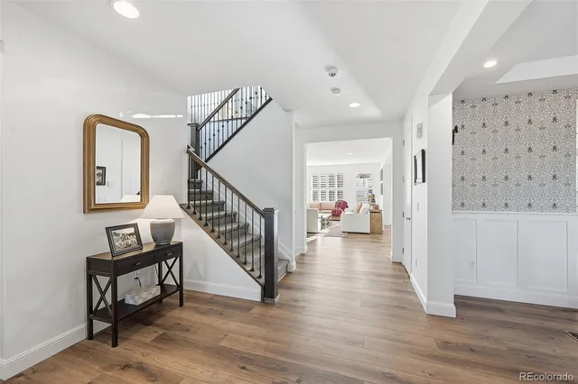 a view of a hallway with wooden floor and stairs