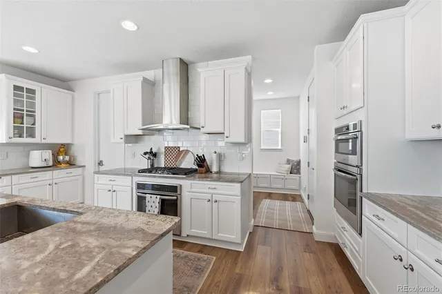 a kitchen with stainless steel appliances granite countertop a sink stove and cabinets