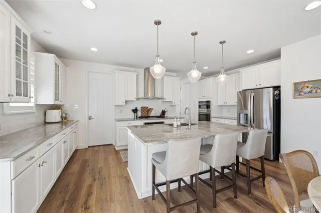 a kitchen with stainless steel appliances granite countertop a sink a stove and cabinets