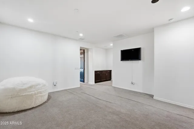 a view of a hallway with wooden floor and a bathroom
