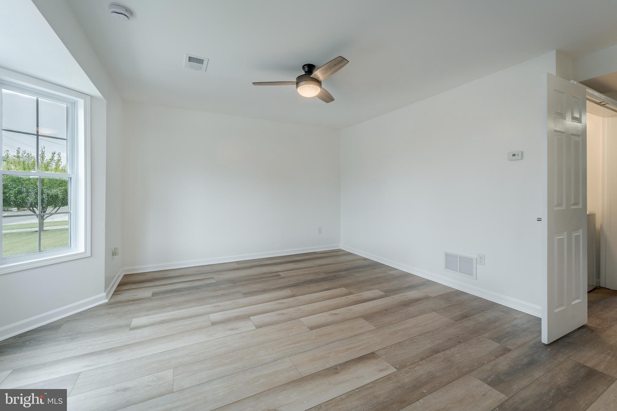 807 Washington Road Westminster, MD 21157 - Photo 4 of 32 an empty room with wooden floor and windows