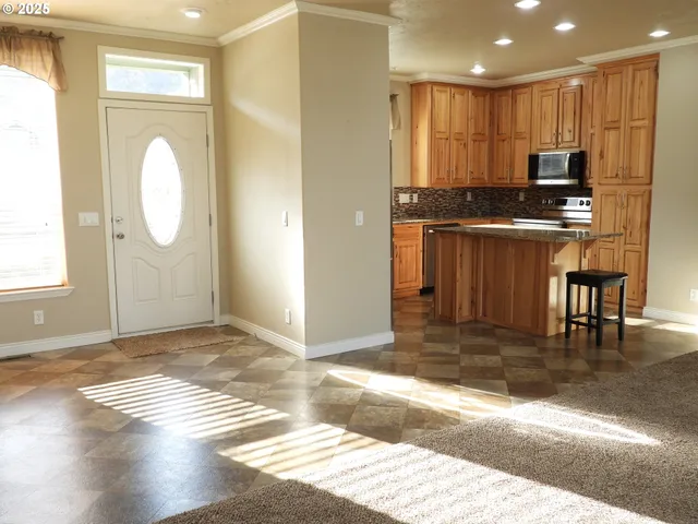 a view of kitchen with granite countertop window and stainless steel appliances
