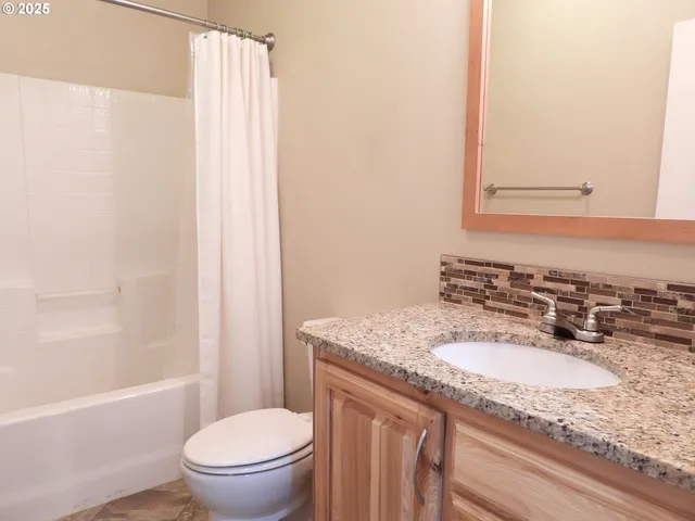a bathroom with a granite countertop sink toilet and shower