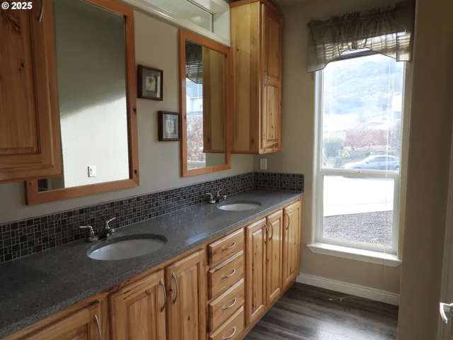 a bathroom with a granite countertop sink and a large mirror