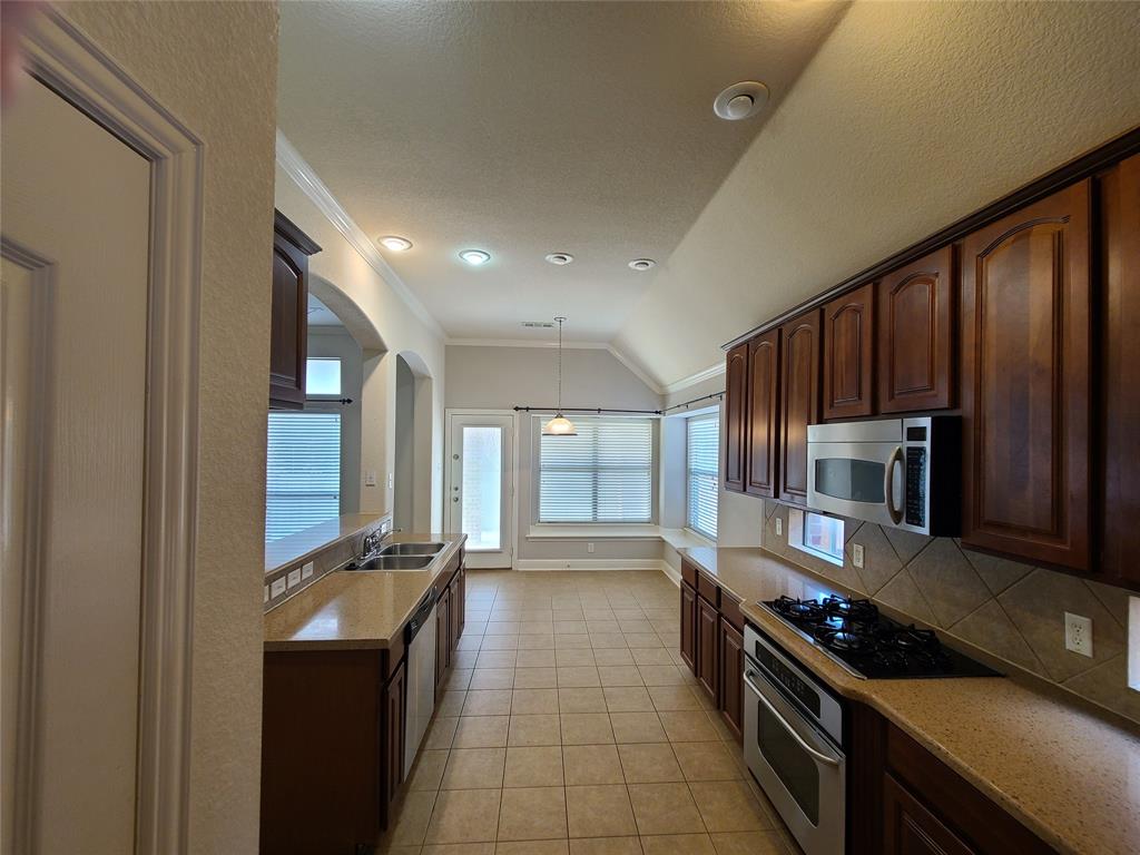 9729 Stripling Drive Fort Worth, TX 76244 - Photo 7 of 40 a kitchen with stainless steel appliances a refrigerator and a stove