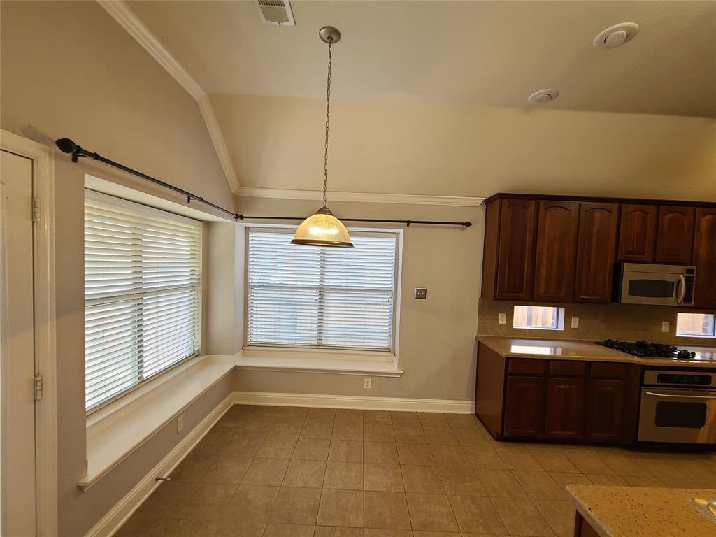 9729 Stripling Drive Fort Worth, TX 76244 - Photo 8 of 40 a kitchen with a refrigerator a stove and a microwave oven