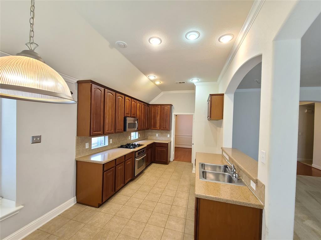 9729 Stripling Drive Fort Worth, TX 76244 - Photo 9 of 40 a kitchen with stainless steel appliances granite countertop a sink stove and refrigerator