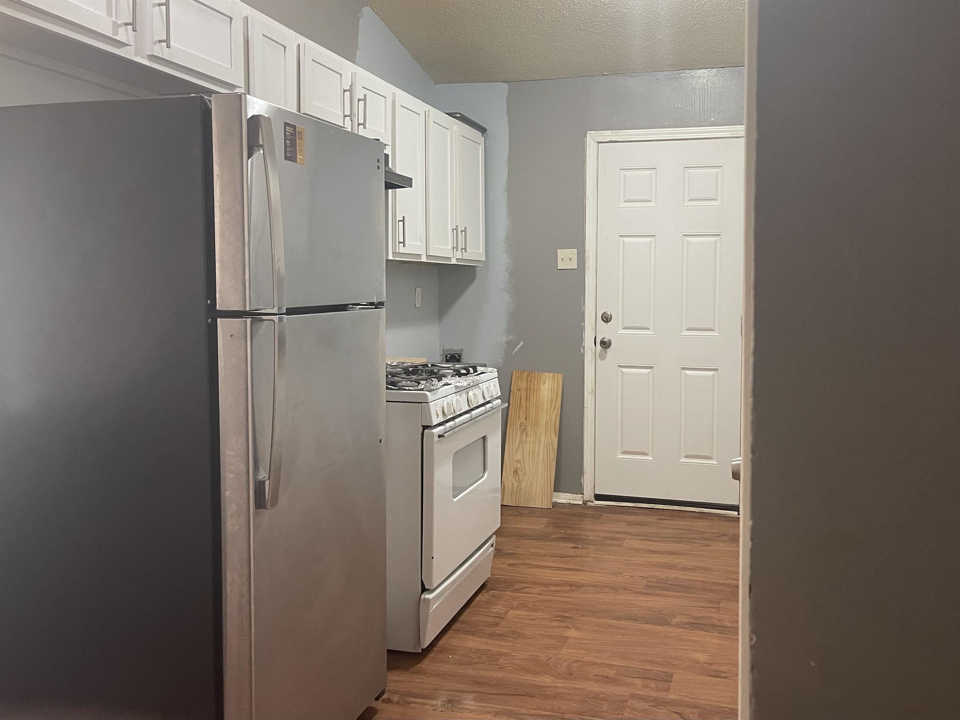 3312 Powell Avenue Memphis, TN 38122 - Photo 5 of 15 a kitchen with a refrigerator a stove and white cabinets