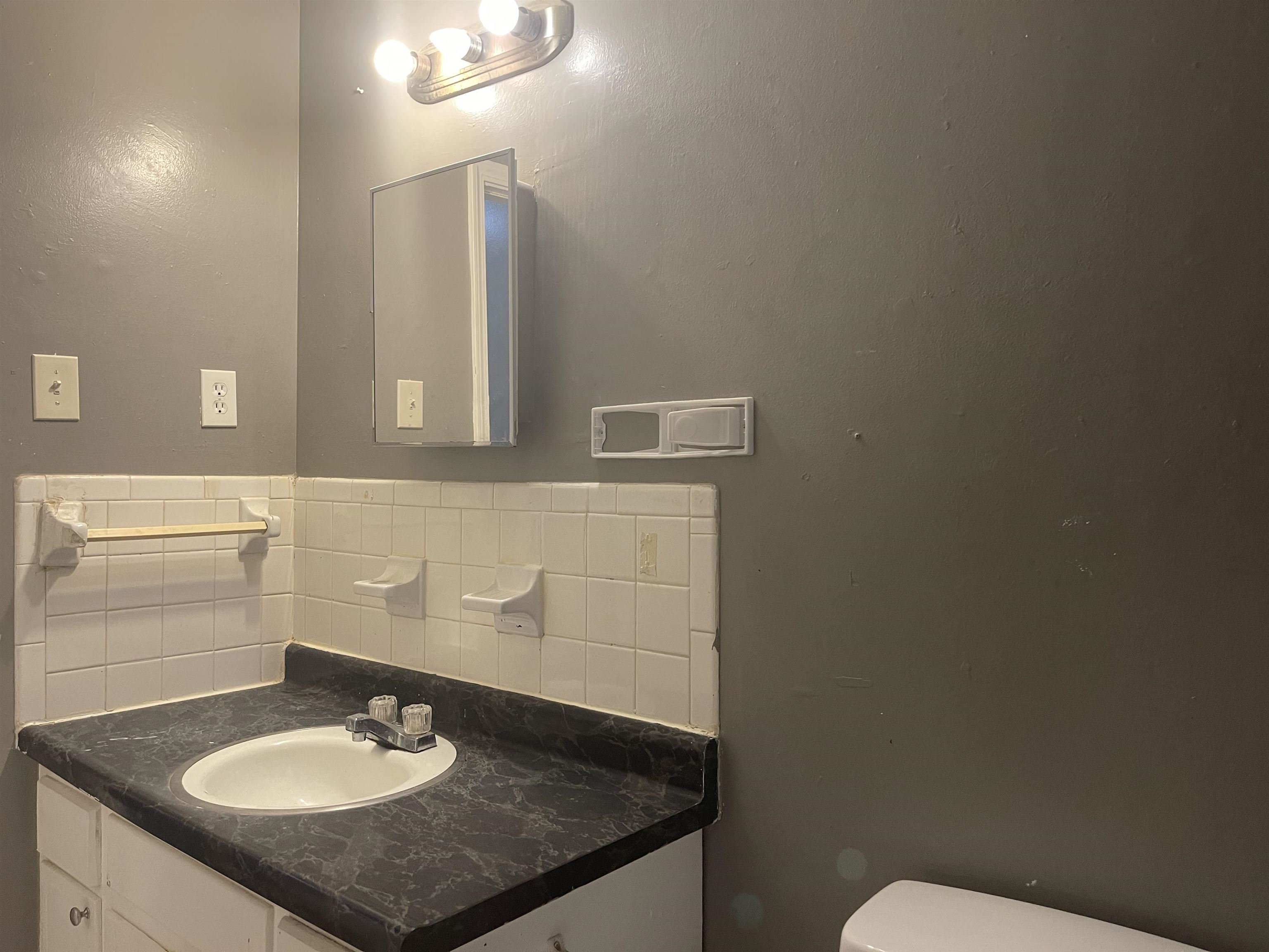 3312 Powell Avenue Memphis, TN 38122 - Photo 8 of 15 a bathroom with a granite countertop sink and a mirror