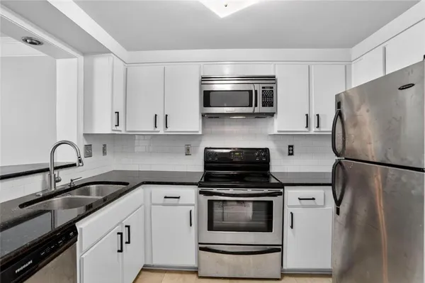 a spacious bathroom with a double vanity sink a mirror and a bathtub