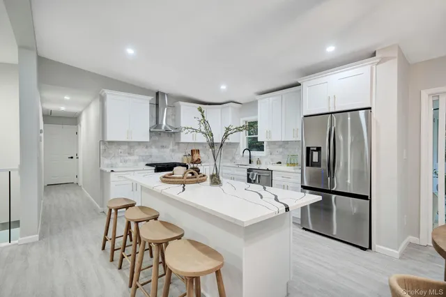 a kitchen with refrigerator a sink and chairs