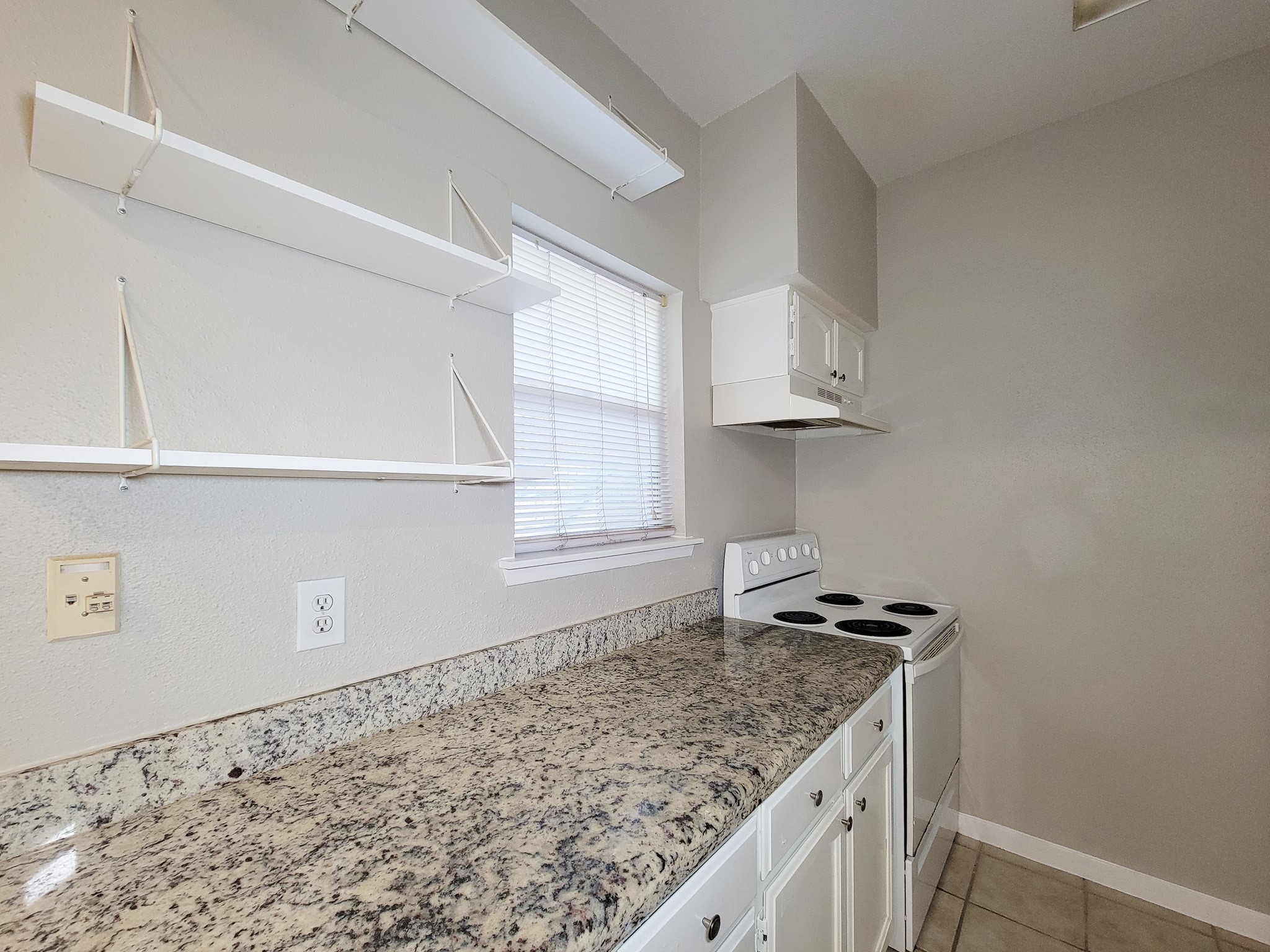 4041 Drake Street, Unit 116 Houston, TX 77005 - Photo 10 of 27 a kitchen with granite countertop a sink cabinets and window