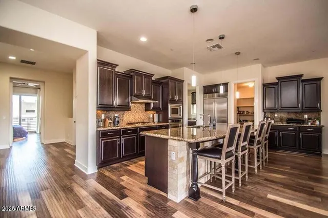 a kitchen with kitchen island granite countertop a stove refrigerator and cabinets