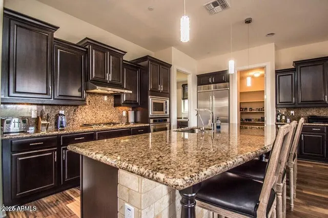 a dining hall with stainless steel appliances granite countertop a granite counter tops and a view of living room