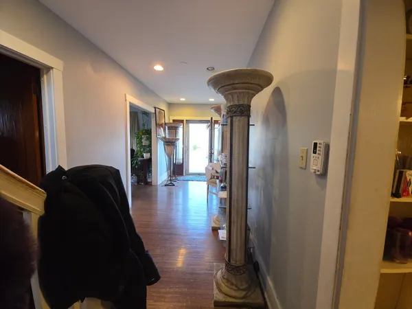 a view of a hallway with wooden floor and furniture