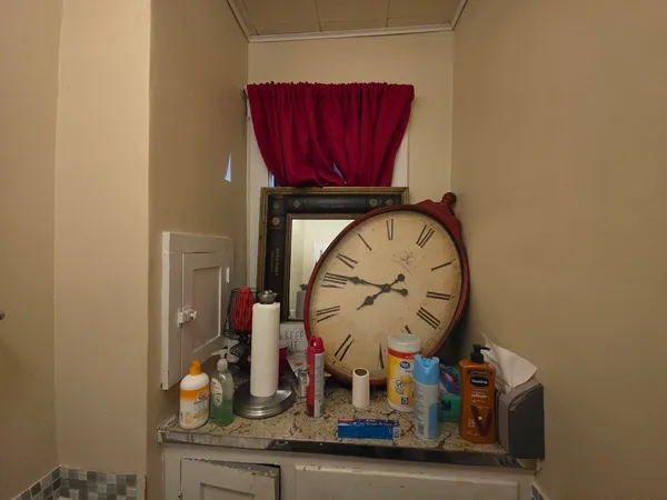 a room with a clock on the wall and a mirror