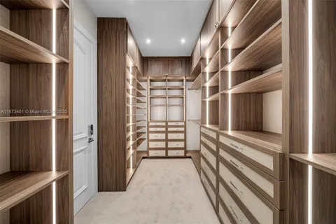 a view of a kitchen with kitchen island a sink a counter top space and cabinets
