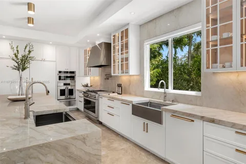 a kitchen with stainless steel appliances granite countertop white cabinets a stove a sink and dishwasher next to a window