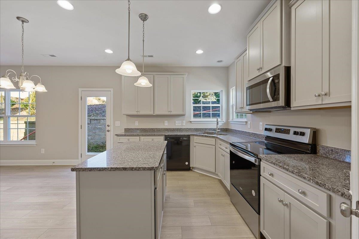 2178 Campbell Loop Burlington, NC 27215 - Photo 11 of 30 a kitchen with stainless steel appliances granite countertop a stove a sink and a microwave