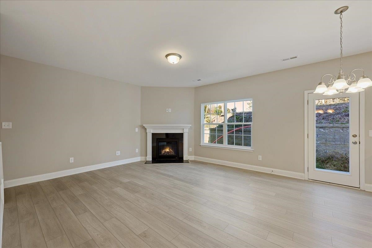2178 Campbell Loop Burlington, NC 27215 - Photo 6 of 30 wooden floor in an empty room with a fireplace