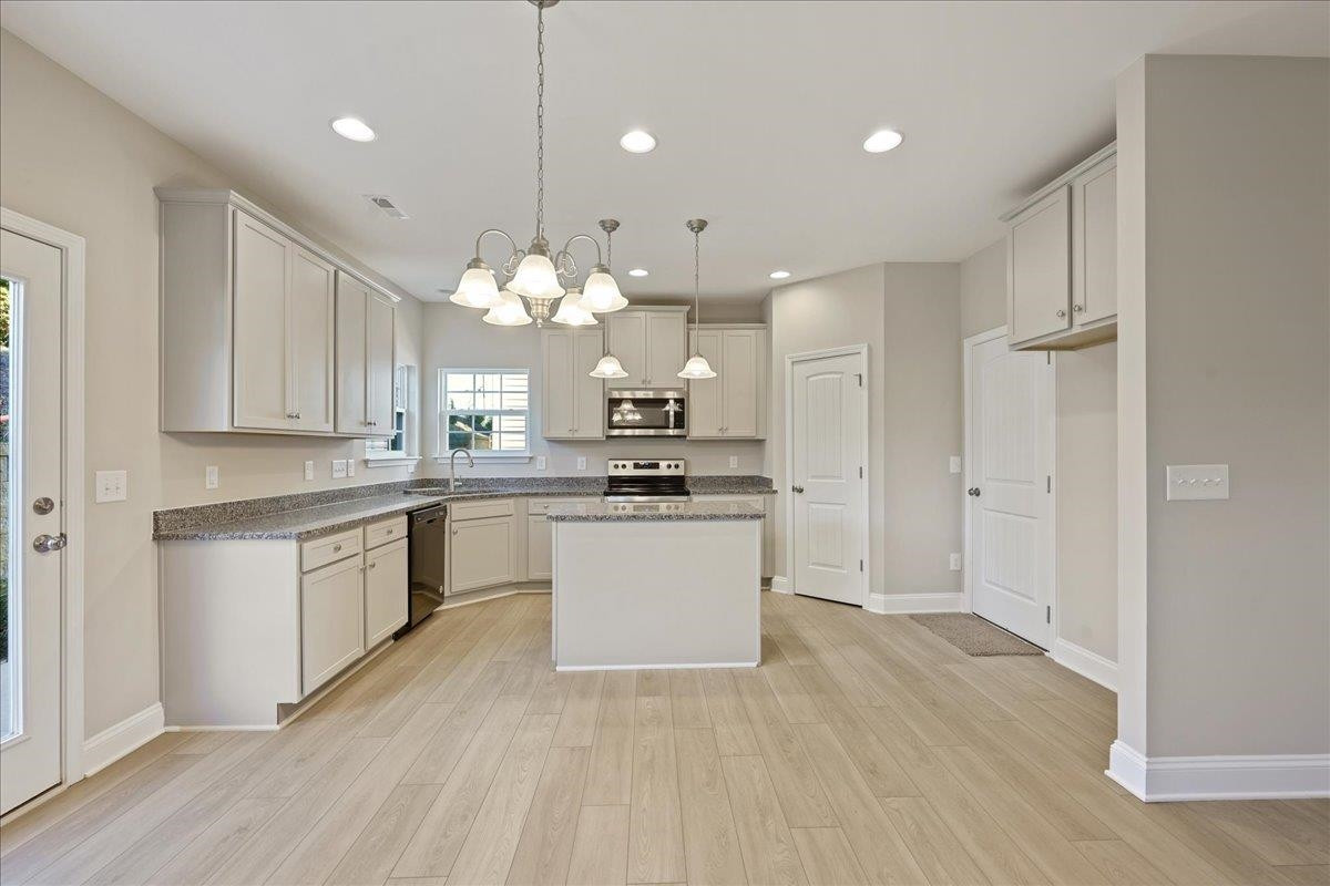 2178 Campbell Loop Burlington, NC 27215 - Photo 8 of 30 a kitchen with a refrigerator a sink dishwasher a stove and white cabinets with wooden floor