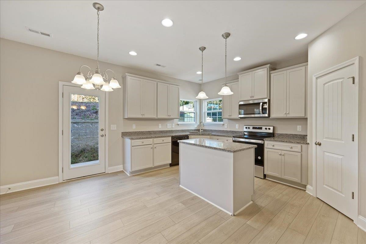 2178 Campbell Loop Burlington, NC 27215 - Photo 9 of 30 a kitchen with kitchen island granite countertop stainless steel appliances cabinets a sink and a chandelier
