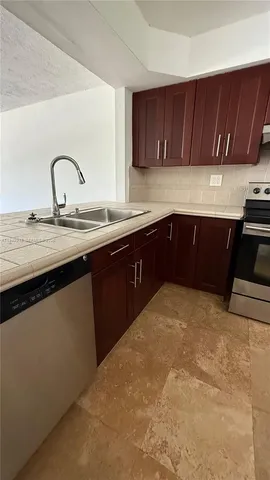 a kitchen with granite countertop a sink and wooden cabinets