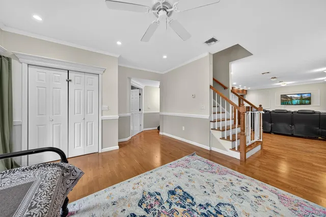 a bedroom with a bed and a chandelier fan
