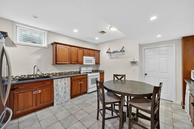 a kitchen with granite countertop white cabinets and stainless steel appliances
