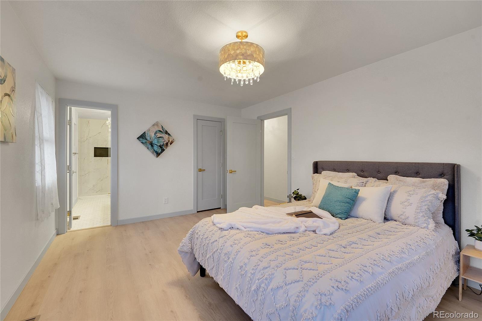 830 Welch Street Golden, CO 80401 - Photo 20 of 37 a bedroom with a bed and a chandelier