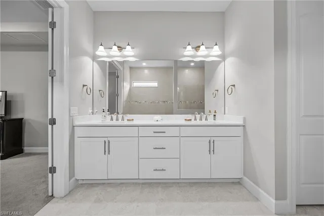 a bathroom with double vanity sinks and a mirror