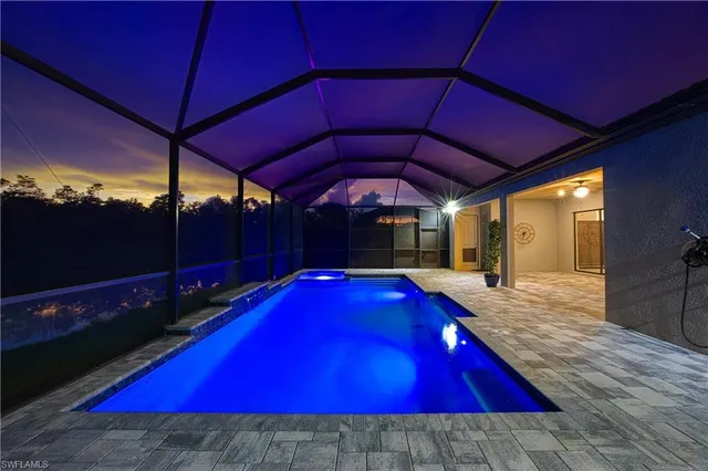 a view of pool with a table and chair under an umbrella