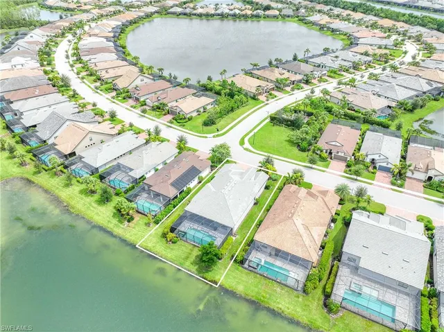 an aerial view of residential houses with outdoor space and lake view