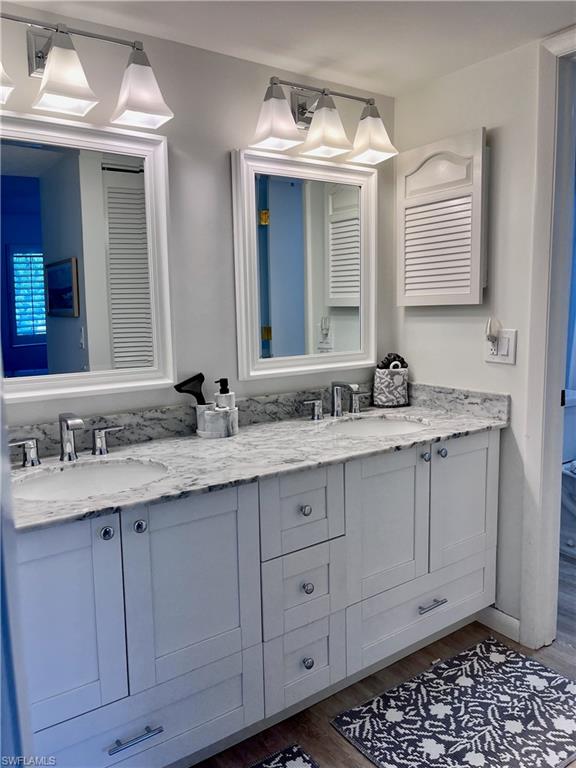 232 Memory Lane, Unit 4 Naples, FL 34112 - Photo 11 of 33 a bathroom with a granite countertop sink and a mirror