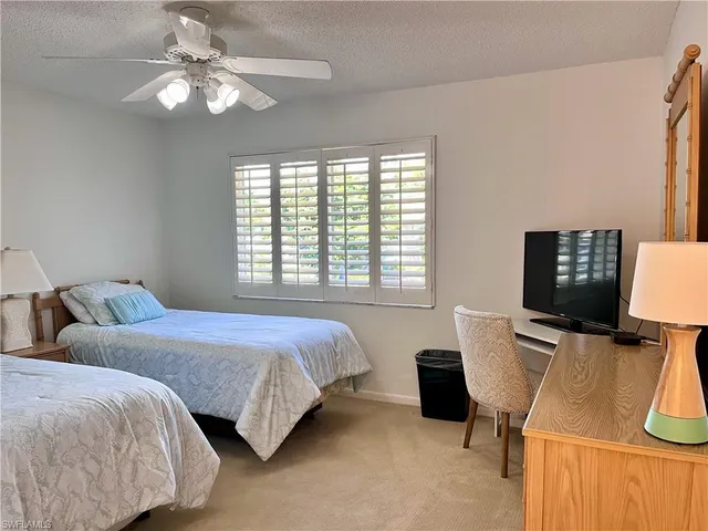 a bedroom with two bed and a desk