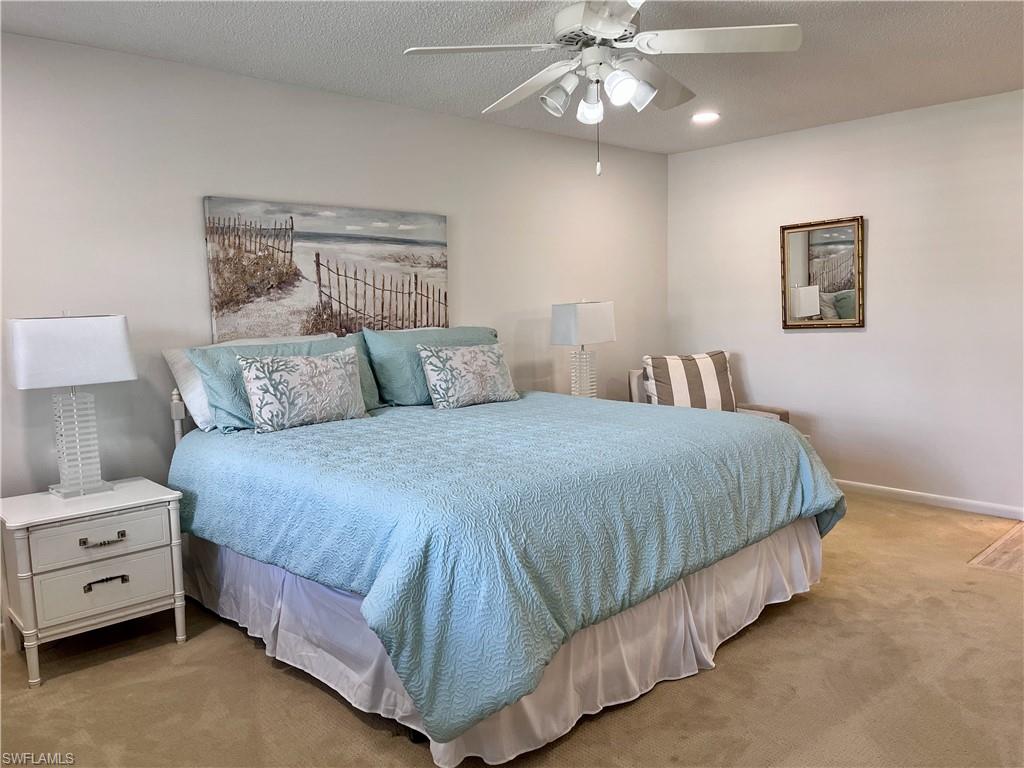 232 Memory Lane, Unit 4 Naples, FL 34112 - Photo 13 of 33 a bedroom with a bed and a chandelier