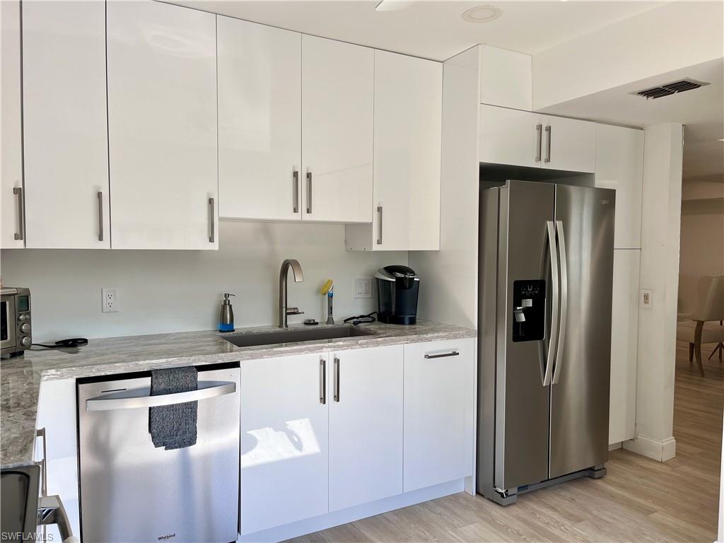 232 Memory Lane, Unit 4 Naples, FL 34112 - Photo 7 of 33 a kitchen with stainless steel appliances granite countertop a refrigerator a sink and white cabinets