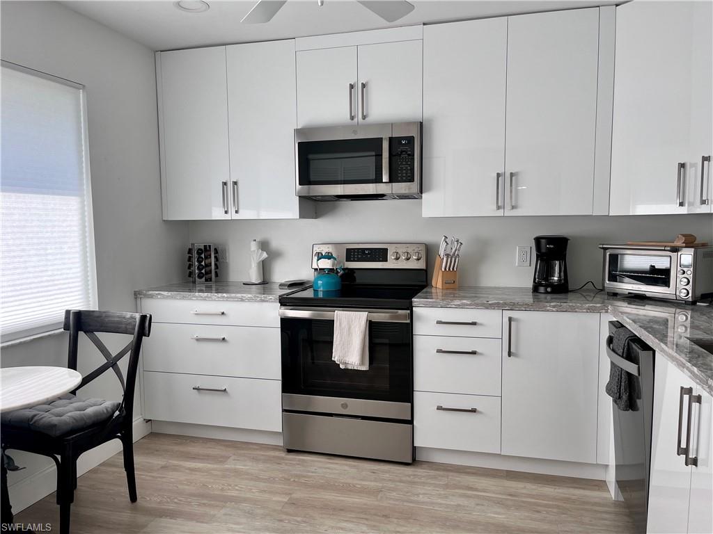 232 Memory Lane, Unit 4 Naples, FL 34112 - Photo 9 of 33 a kitchen with granite countertop white cabinets and black appliances