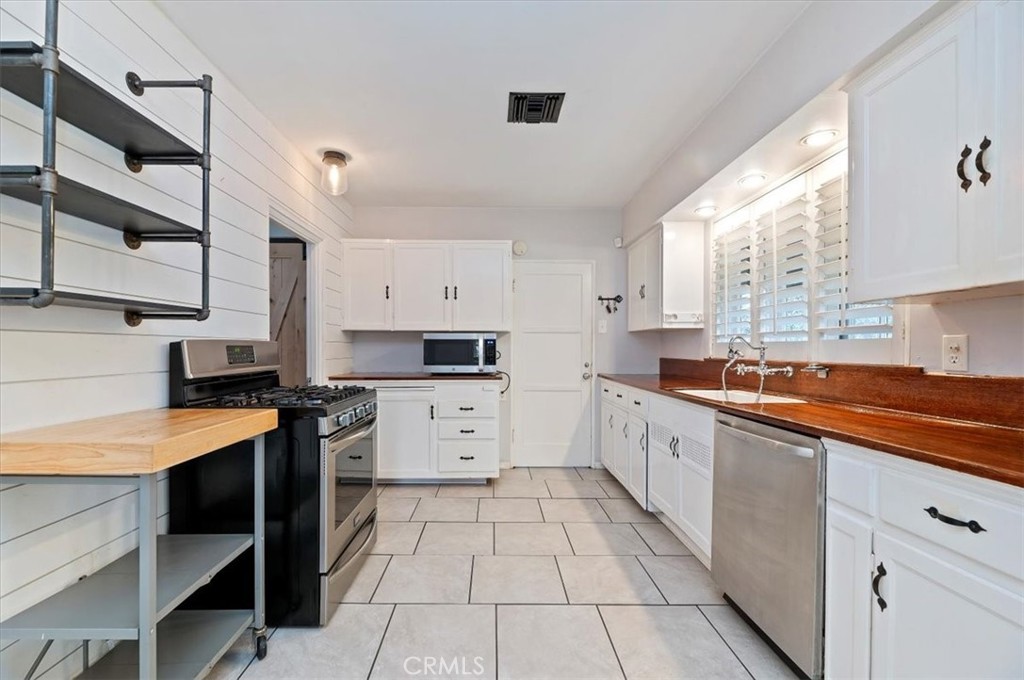 3630 Castle Reagh Place Riverside, CA 92506 - Photo 11 of 37 a large kitchen with stainless steel appliances granite countertop a sink and cabinets