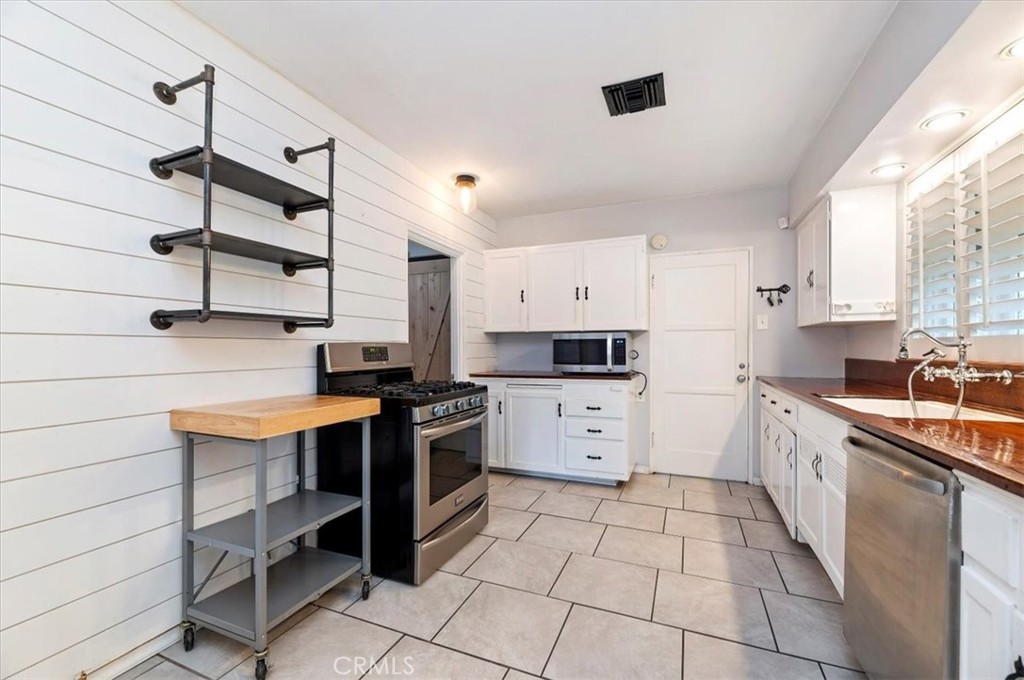 3630 Castle Reagh Place Riverside, CA 92506 - Photo 12 of 37 a kitchen with stainless steel appliances a stove sink and cabinets