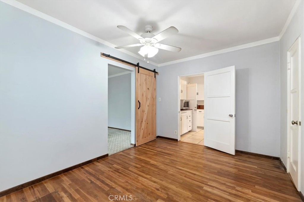 3630 Castle Reagh Place Riverside, CA 92506 - Photo 23 of 37 a view of an empty room with wooden floor and a ceiling fan