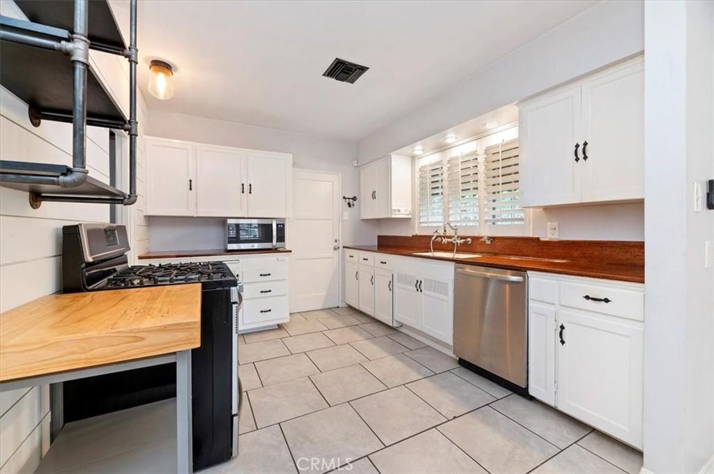 3630 Castle Reagh Place Riverside, CA 92506 - Photo 10 of 37 a kitchen with stainless steel appliances granite countertop a stove a sink and white cabinets