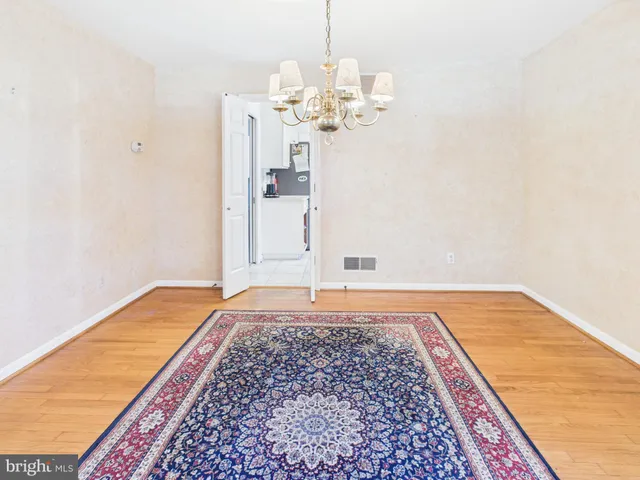 a view of a bedroom with wooden floor and chandelier