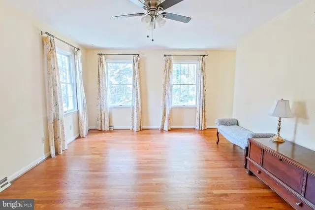 a view of a livingroom with furniture window wooden floor and a ceiling fan
