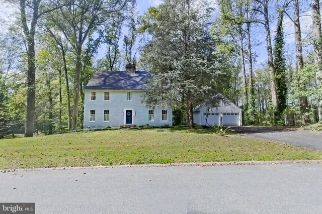 a front view of a house with a garden and tree